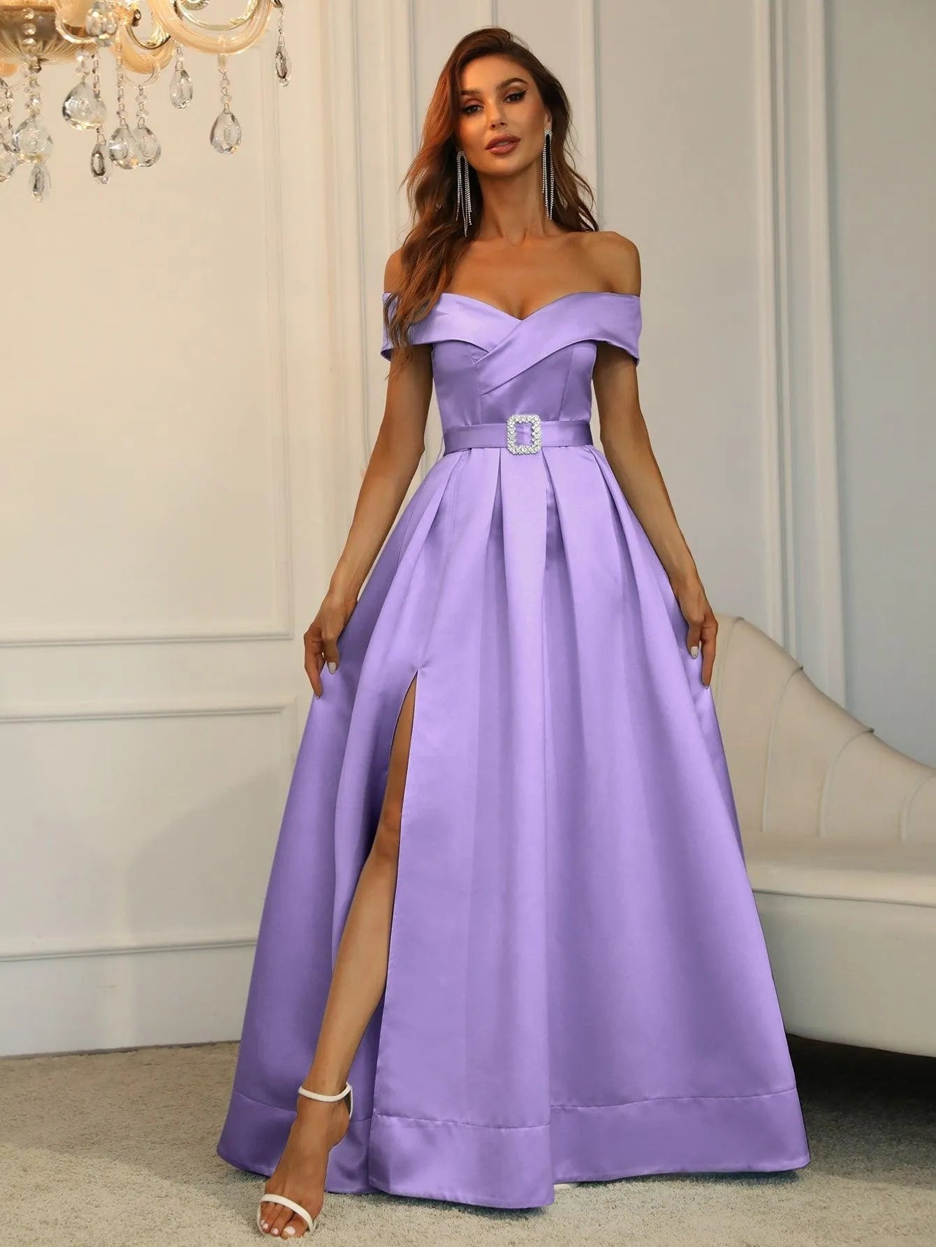 Vestido largo lila con escote off shoulder y cinturón decorativo.