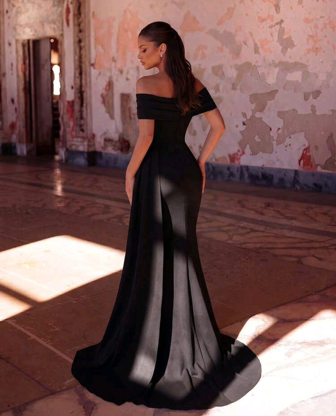 Vestido negro off-the-shoulder con abertura lateral